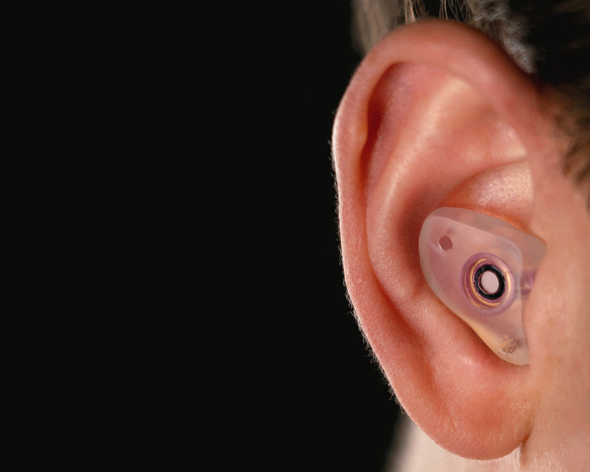 The One filtered earplug seated in the ear, with its flat filter in the face of the plug
