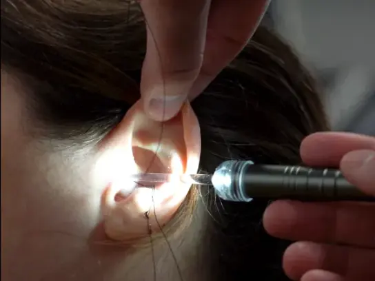 A technician checks the ear canal with an otoscope before a Big Ear impression